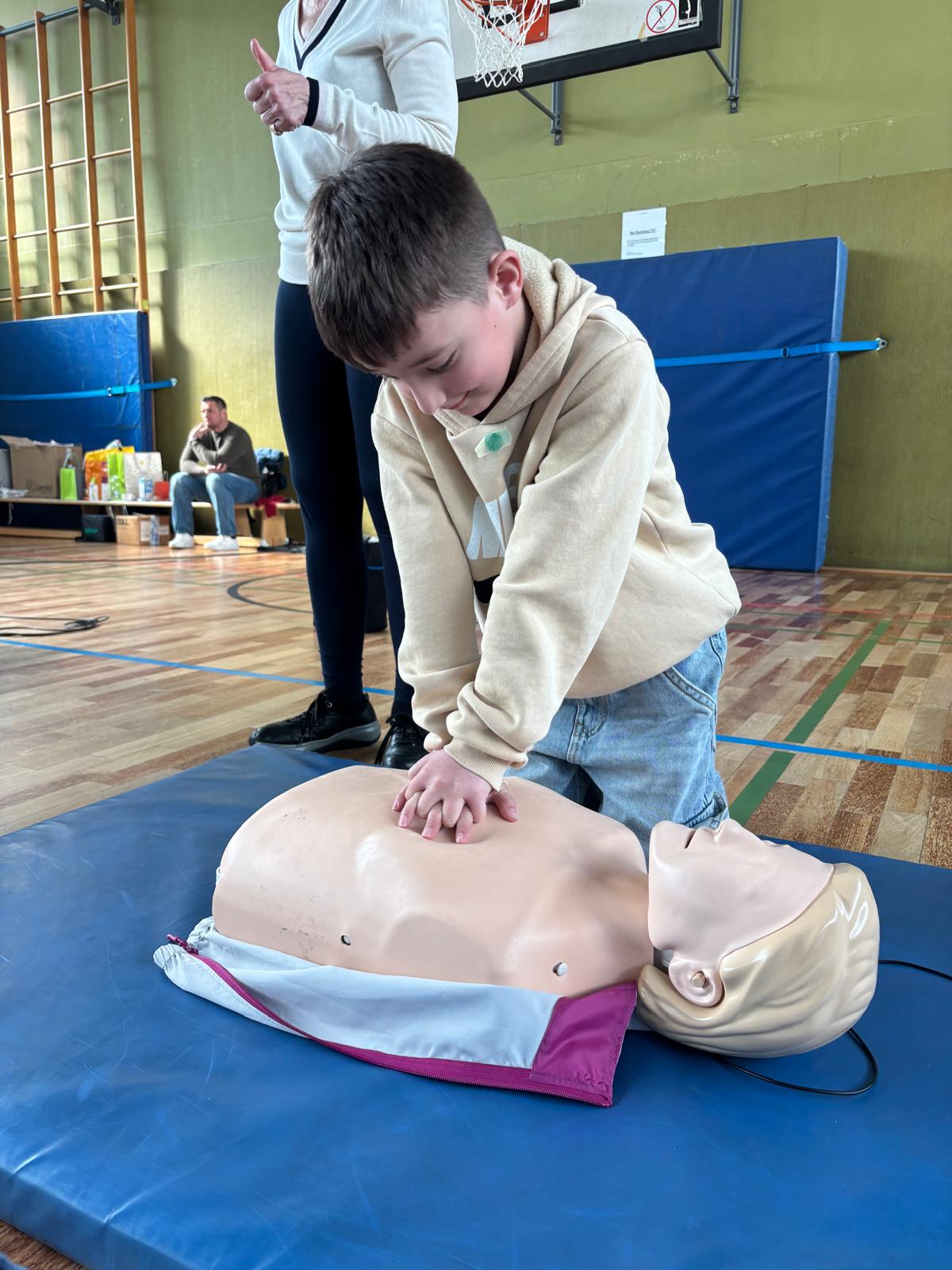 Kind übt Herzdruckmassage